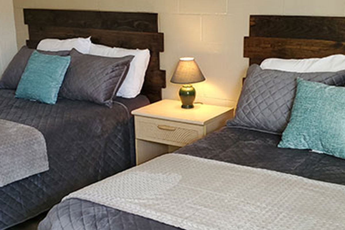 Image of made beds inside motel room with new, wooden headboards