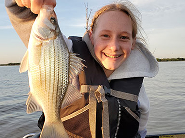 Teenage girl holding a fish in Lake Fork