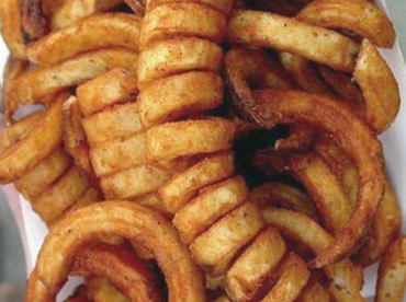 Fried, golden-brown, curly fries on a white plate