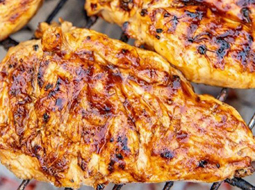 Chicken breast on a grill marinated with a glaze